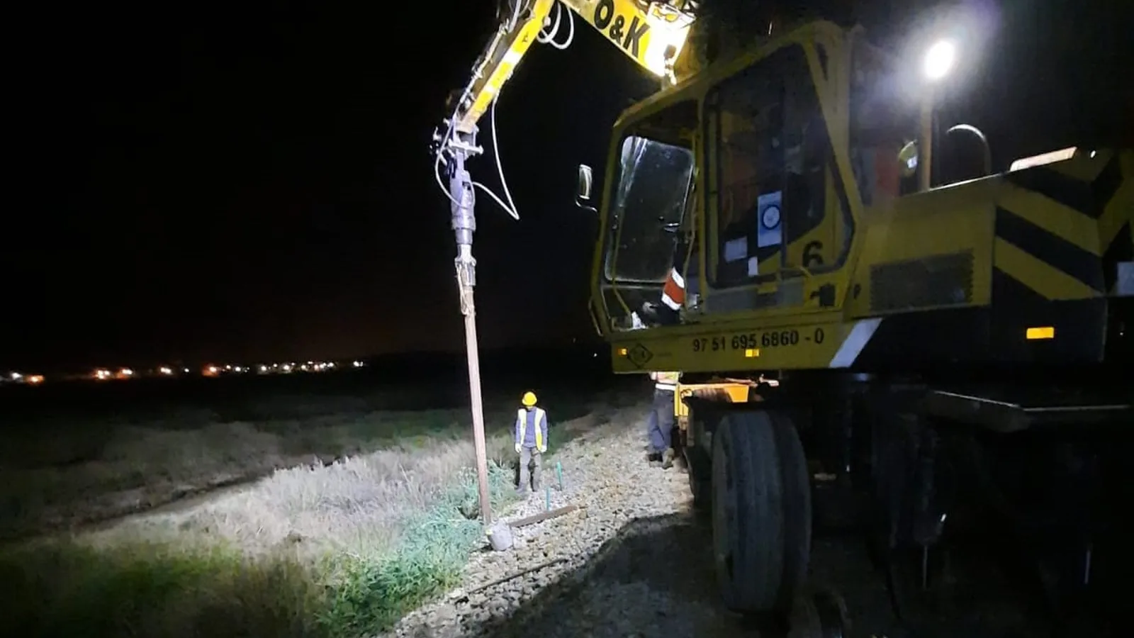 Driving helical piles from the track at night on the Algarve Line